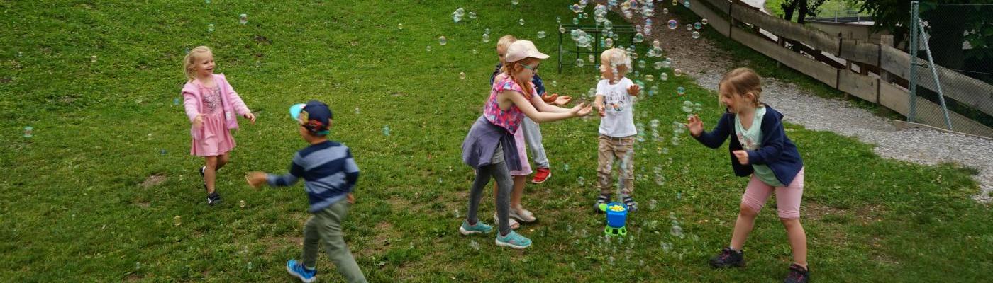 Kinder spielen mit Seifenblasen