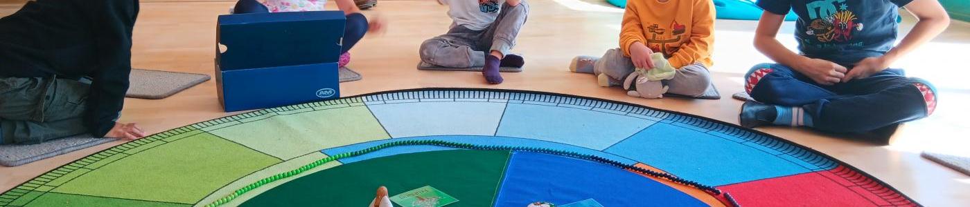 Kinder sitzen an einem Jahreszeitenkreis