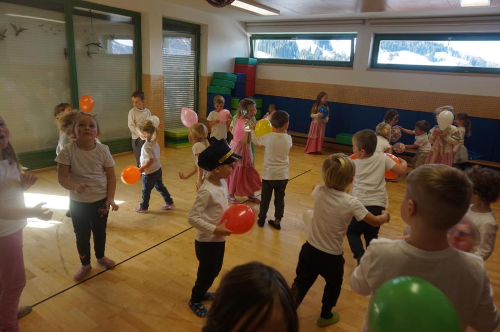 Kinder tanzen einen Luftballontanz