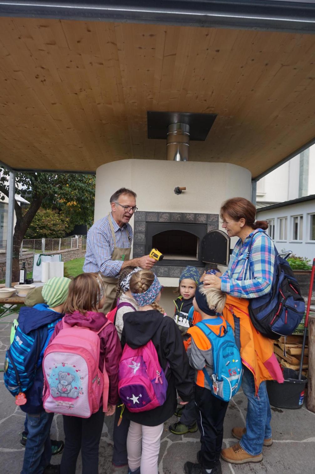 Den Kindern wird der Ofen gezeigt