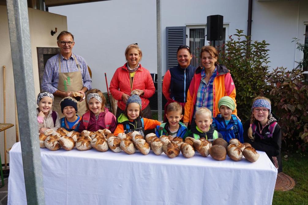 Gruppenfoto der Kinder mit den Bäckern und dem Brot