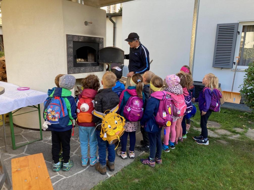 Kinder schauen in den Brotbackofen