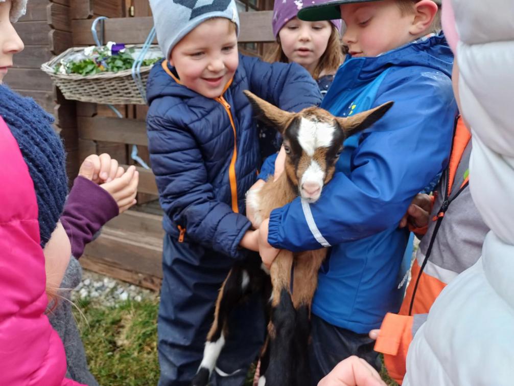 Kinder halten eine Ziege