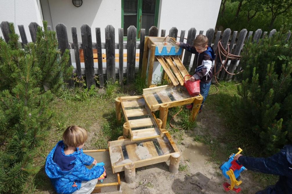 Kinder spielen mit dem Wasserspiel