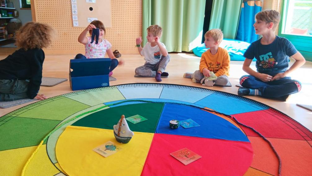 Kinder sitzen an einem Jahreszeitenkreis