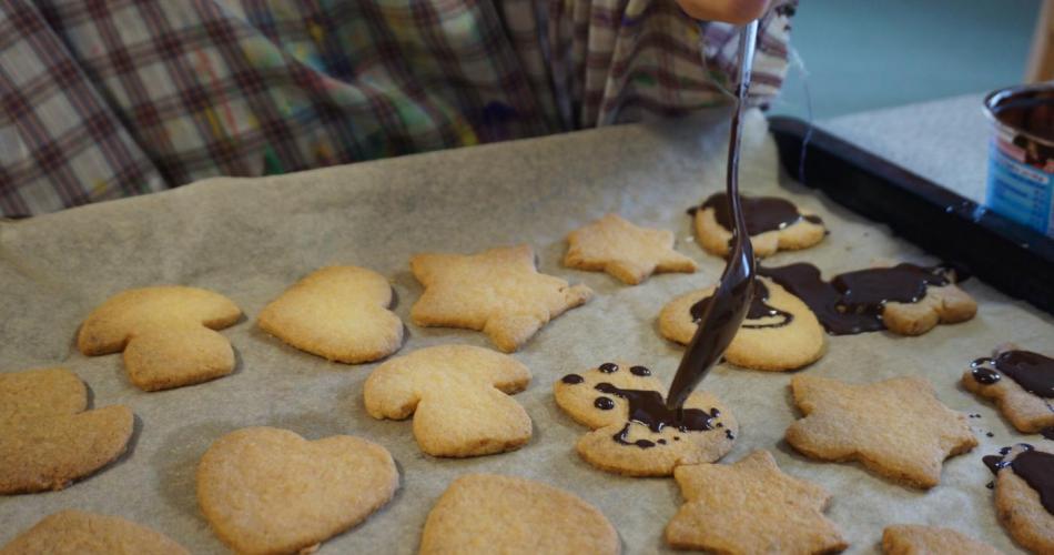 Kekse werden mit Schokolade beträufelt