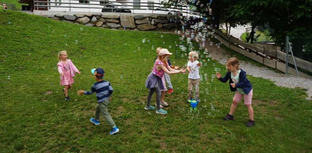 Kinder spielen mit Seifenblasen