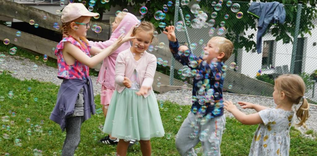 Kinder spielen mit Seifenblasen