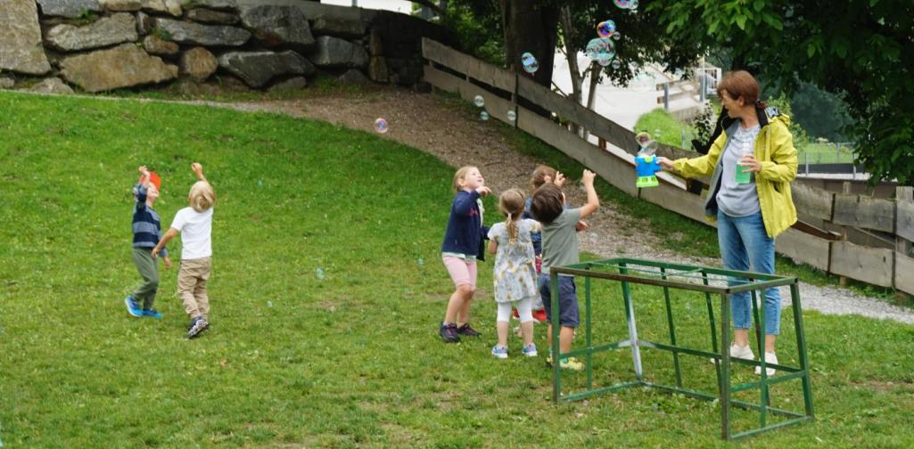 Kinder spielen mit Seifenblasen