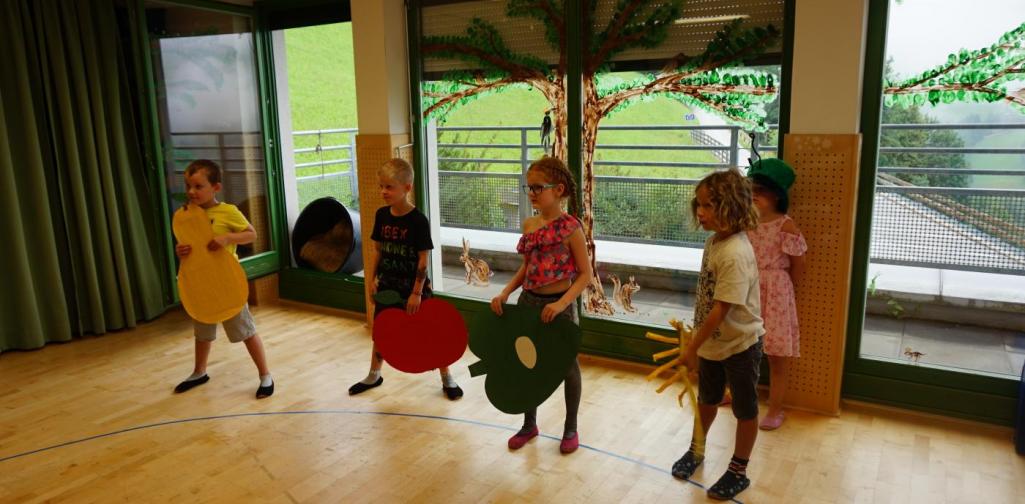 Kinder spielen die kleine Raupe Nimmersatt