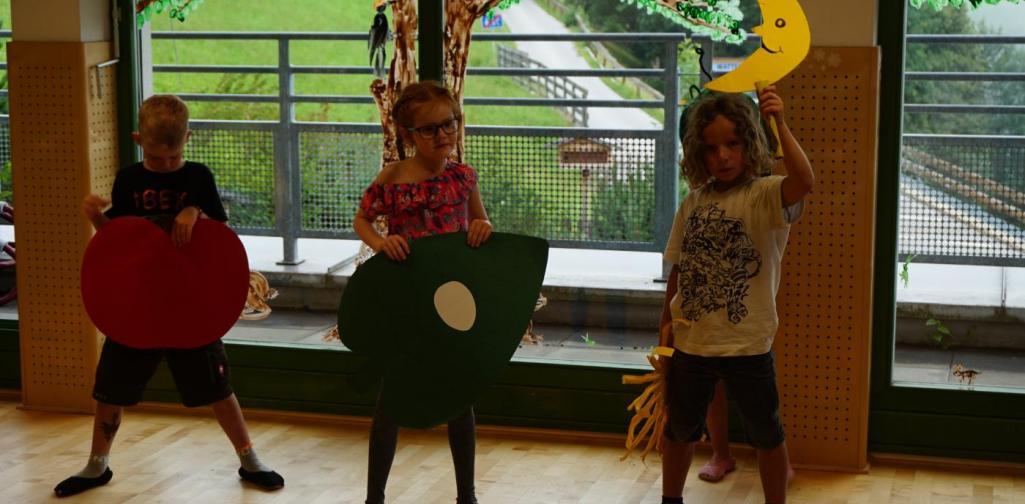 Kinder spielen die kleine Raupe Nimmersatt