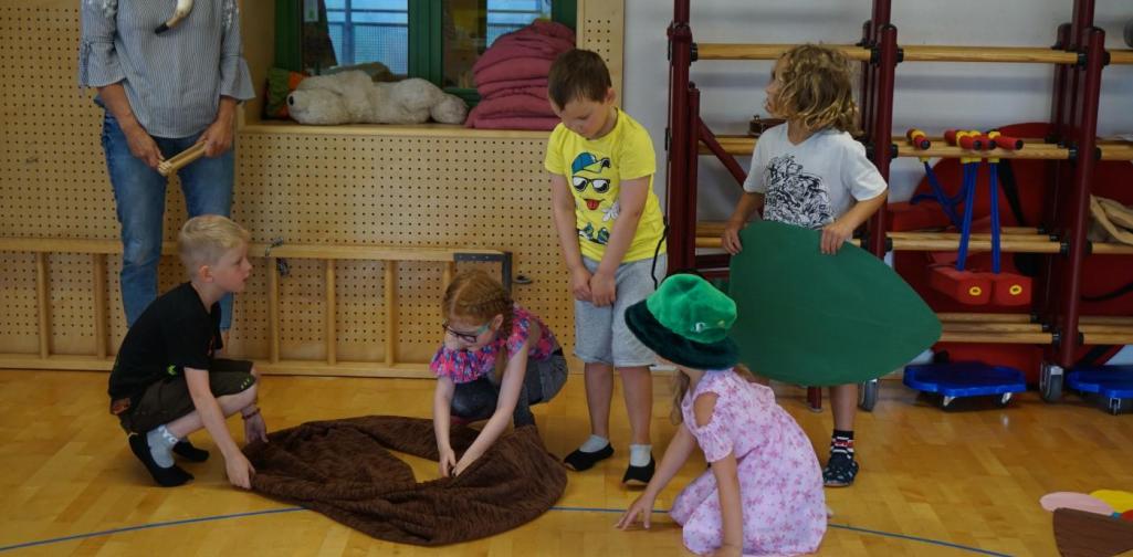 Kinder spielen die kleine Raupe Nimmersatt