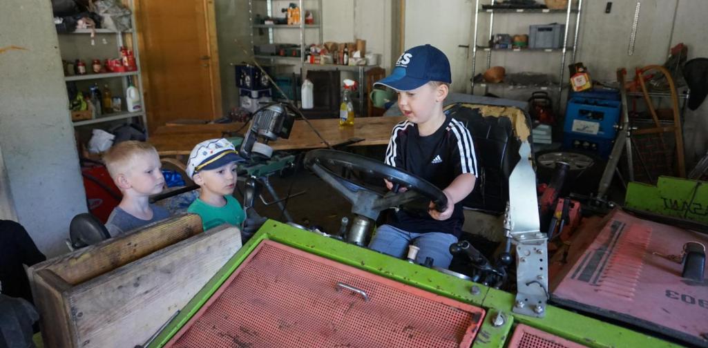 Kind darf am Mähtrack sitzen